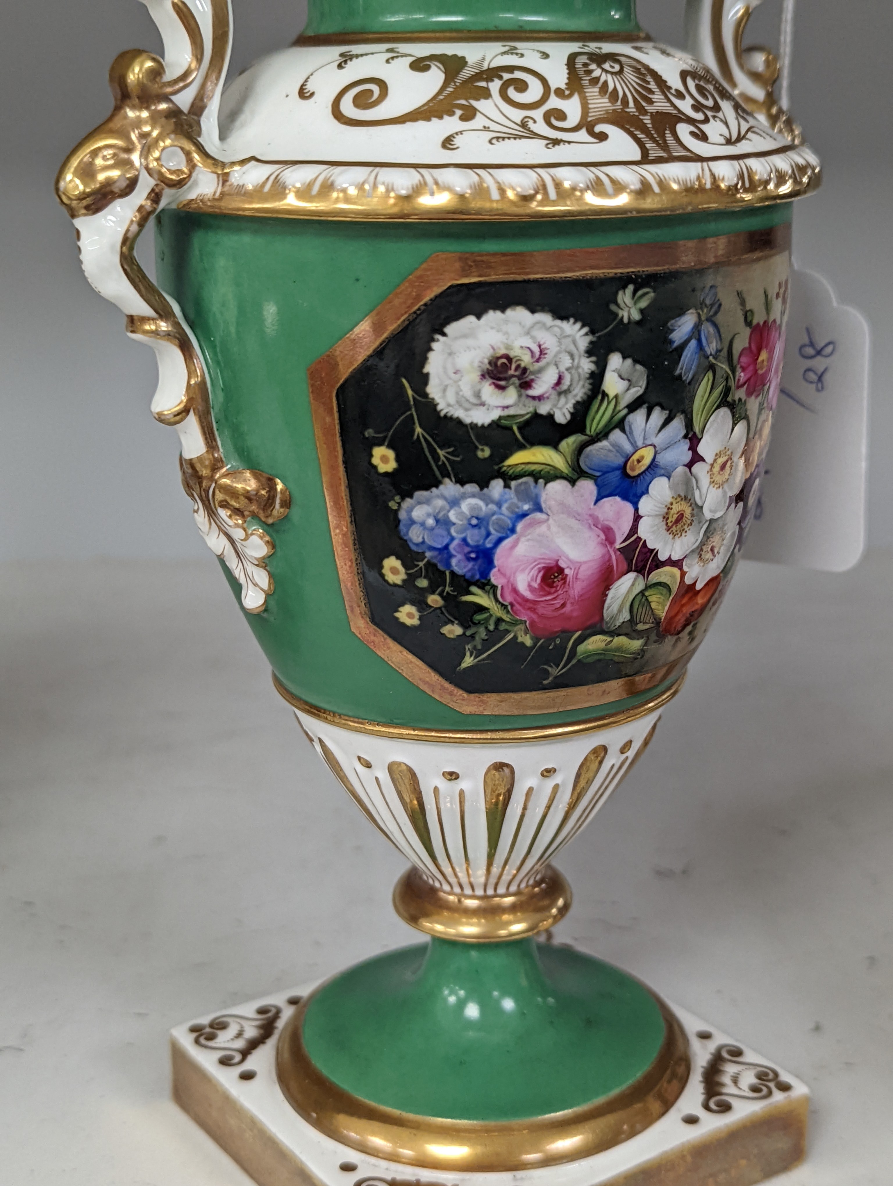 An English porcelain two handled vase painted with flowers in a panel on a green ground, probably Grainger Worcester, c.1830, height 24cm
